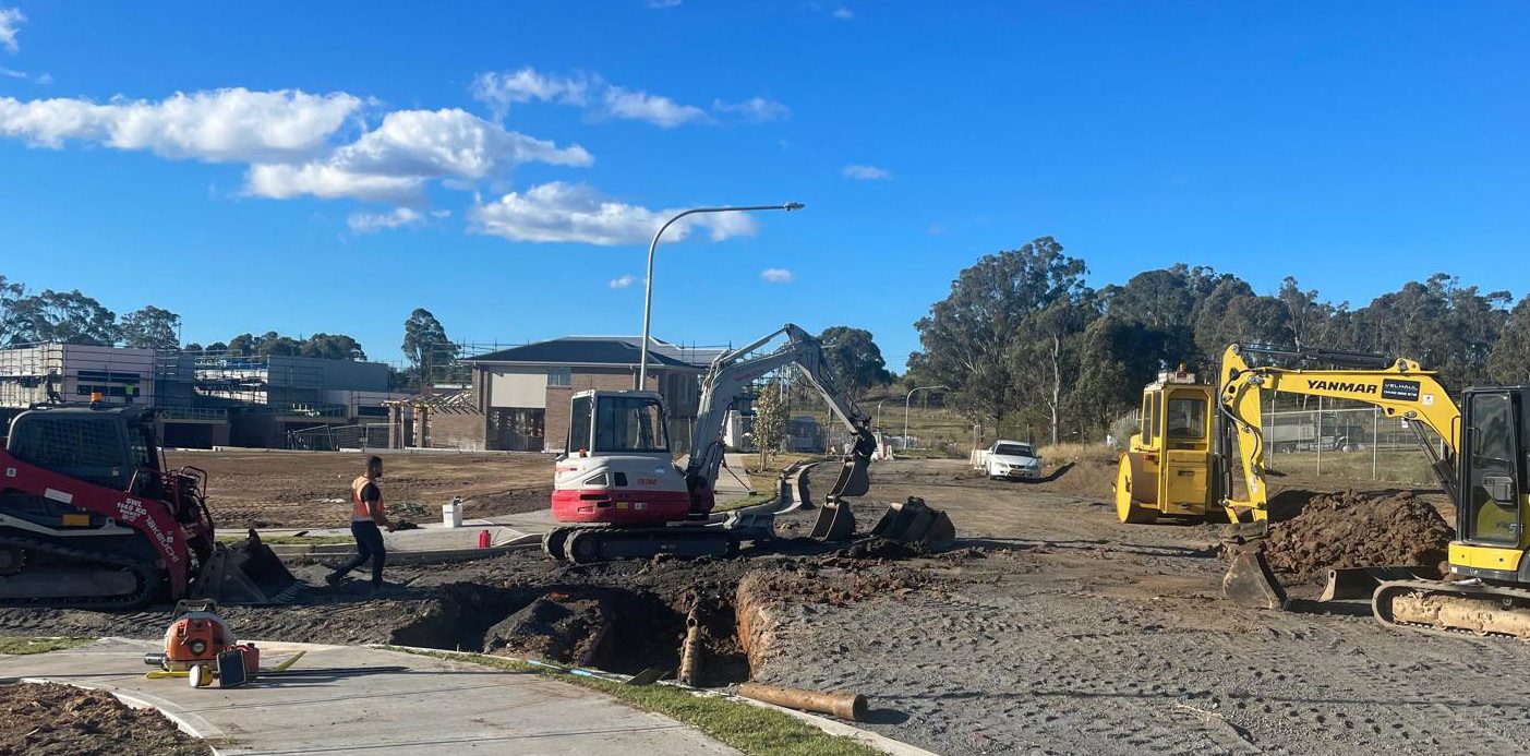 28th Avenue Austral — civil works in progress with We Build Australia excavator, tracked loader and earthworks on subdivision site