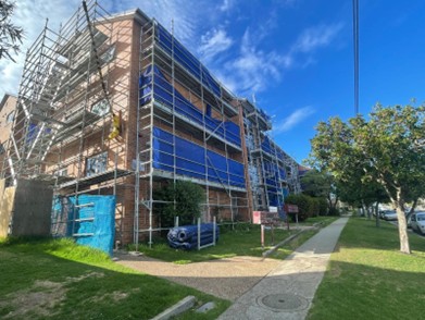 Bar Beach — scaffolded LAHC residential building with blue protective sheeting during the window and door replacement programme