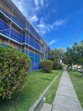 Bar Beach — side elevation of the scaffolded brick LAHC building during remedial works and window replacement