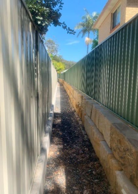 Kincumber — completed sandstone retaining wall and pedestrian path between residential properties on the Central Coast