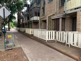 Walker Street, Waterloo — BEFORE: weathered LAHC residential block with peeling paint balustrades and aged frontage prior to upgrade
