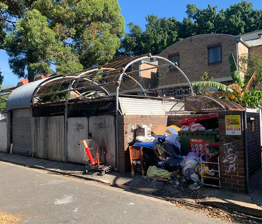 Walker Street, Waterloo — BEFORE: poor-condition rear-lane waste enclosure prior to communal infrastructure upgrade